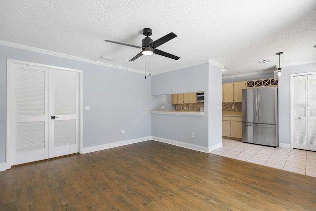 1227 Tuxford Dr, Brandon, FL 33511 - unfurnished living room with a ceiling fan, a textured ceiling, ornamental molding, and wood finished floors