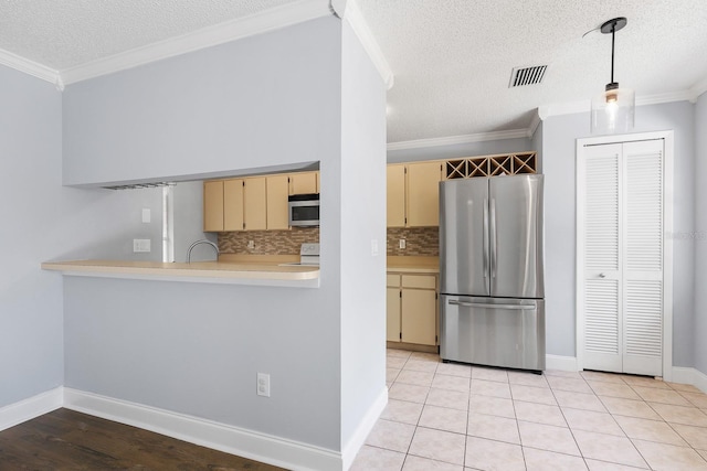 1227 Tuxford Dr, Brandon, FL 33511 - kitchen with light countertops, a textured ceiling, cream cabinets, tasteful backsplash, and stainless steel appliances