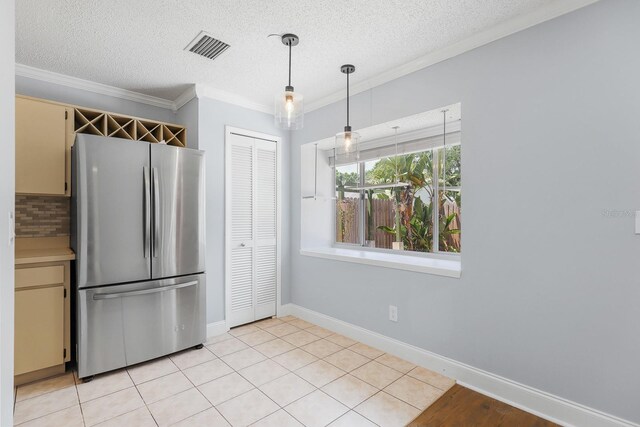 1227 Tuxford Dr, Brandon, FL 33511 - kitchen featuring a textured ceiling, freestanding refrigerator, decorative light fixtures, cream cabinetry, and visible vents