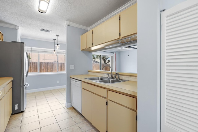 1227 Tuxford Dr, Brandon, FL 33511 - kitchen featuring visible vents, white dishwasher, a sink, freestanding refrigerator, and cream cabinetry