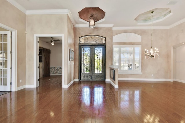 entrance foyer with crown molding, baseboards, and wood-type flooring