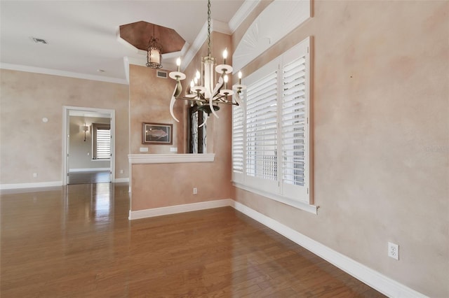 unfurnished dining area with an inviting chandelier, ornamental molding, wood finished floors, and a wealth of natural light