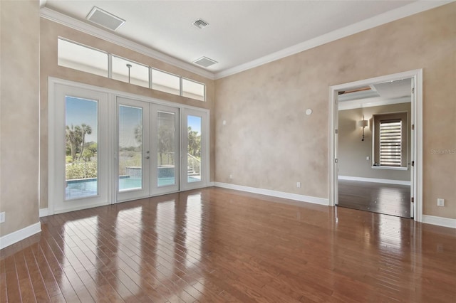 interior space with french doors, baseboards, visible vents, ornamental molding, and hardwood / wood-style flooring