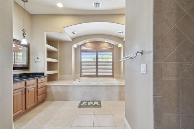 bathroom featuring a bath, visible vents, built in features, tile patterned floors, and vanity