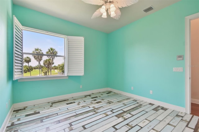 unfurnished room with ceiling fan, visible vents, and baseboards