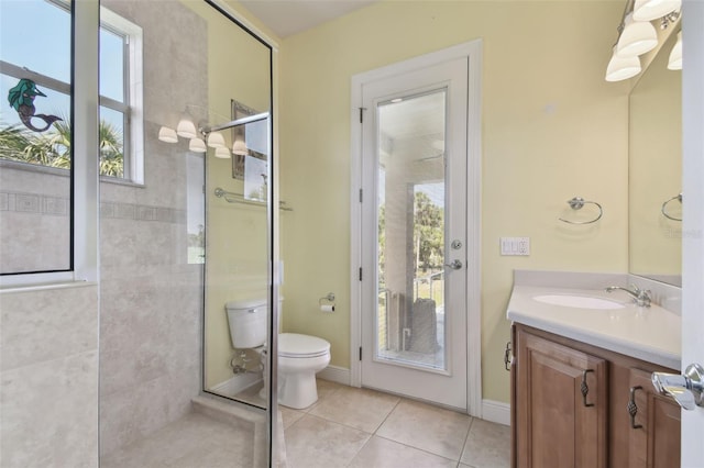 bathroom with toilet, tile patterned floors, tiled shower, and vanity