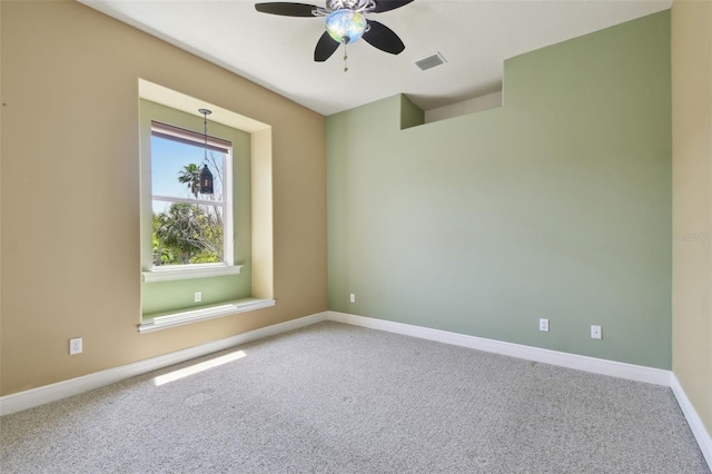 spare room with carpet floors, ceiling fan, baseboards, and visible vents