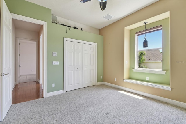unfurnished bedroom with baseboards, carpet, a closet, and visible vents