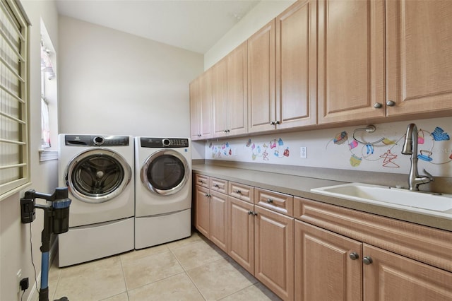laundry room featuring cabinet space, light tile patterned flooring, a sink, and washer and dryer