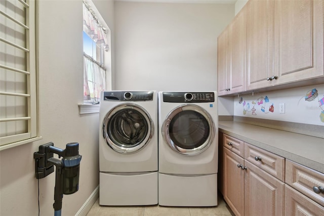 laundry room with cabinet space, independent washer and dryer, baseboards, and light tile patterned floors