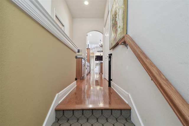 hall with recessed lighting, arched walkways, and baseboards
