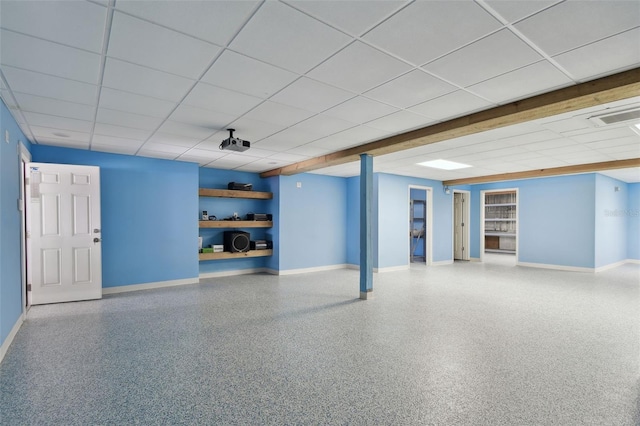interior space with baseboards and a drop ceiling