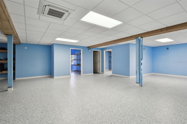 finished basement with visible vents, baseboards, and a paneled ceiling