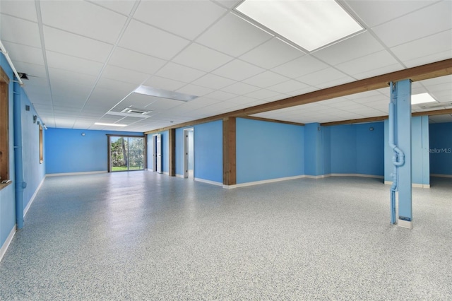 interior space featuring baseboards, visible vents, and a drop ceiling