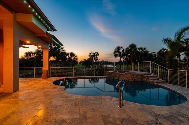 pool at dusk featuring a fenced in pool, a patio, and an in ground hot tub