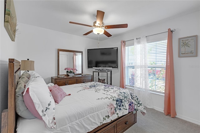 bedroom with baseboards, light carpet, ceiling fan, and multiple windows