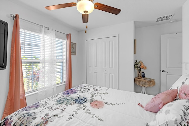 bedroom featuring visible vents, a ceiling fan, and a closet