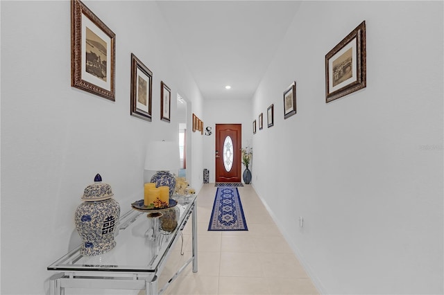 hall featuring recessed lighting, baseboards, and light tile patterned floors