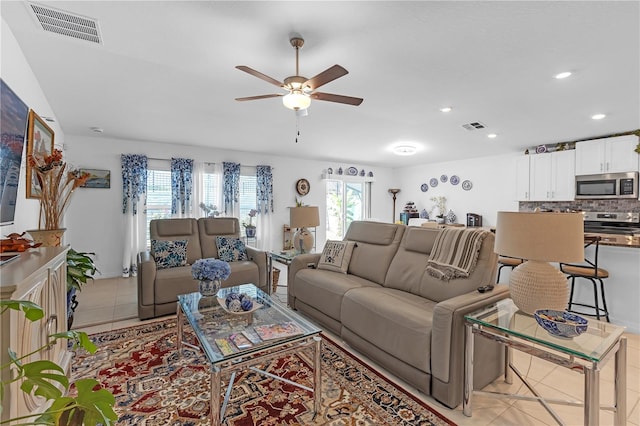 living area with light tile patterned flooring, a ceiling fan, visible vents, and recessed lighting