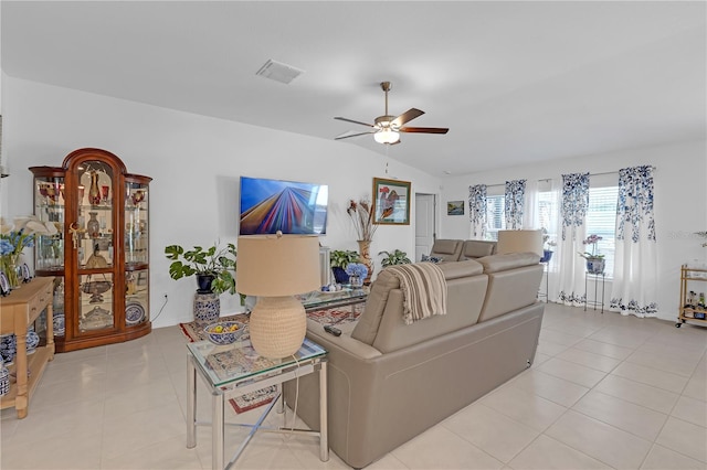living area featuring visible vents, a ceiling fan, light tile patterned flooring, and vaulted ceiling