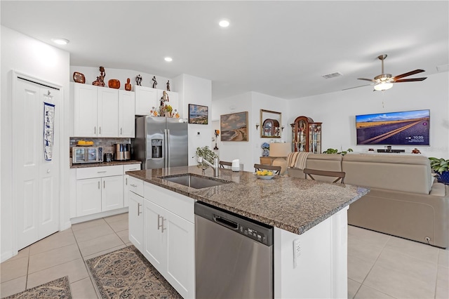 kitchen featuring visible vents, open floor plan, a sink, light tile patterned floors, and stainless steel appliances