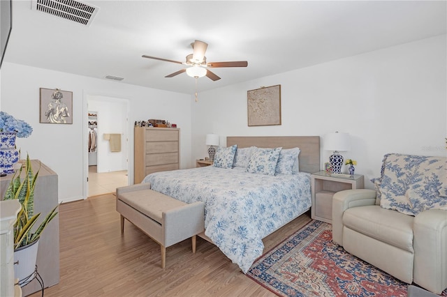 bedroom with a ceiling fan, visible vents, and light wood-style flooring