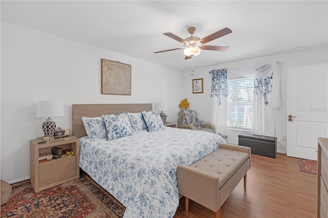 bedroom featuring a ceiling fan, baseboards, and wood finished floors
