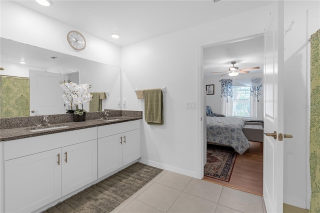 ensuite bathroom featuring tile patterned flooring, a ceiling fan, baseboards, connected bathroom, and a sink