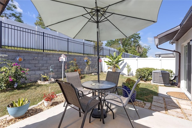 view of patio with cooling unit, outdoor dining space, and a fenced backyard