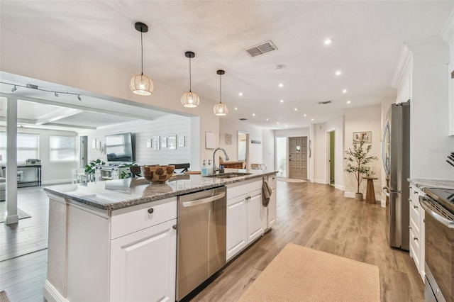 13749 80th Ave, Seminole, FL 33776 - kitchen featuring visible vents, appliances with stainless steel finishes, a sink, white cabinets, and open floor plan