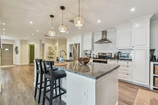 13749 80th Ave, Seminole, FL 33776 - kitchen featuring wall chimney range hood, appliances with stainless steel finishes, recessed lighting, a large island, and visible vents