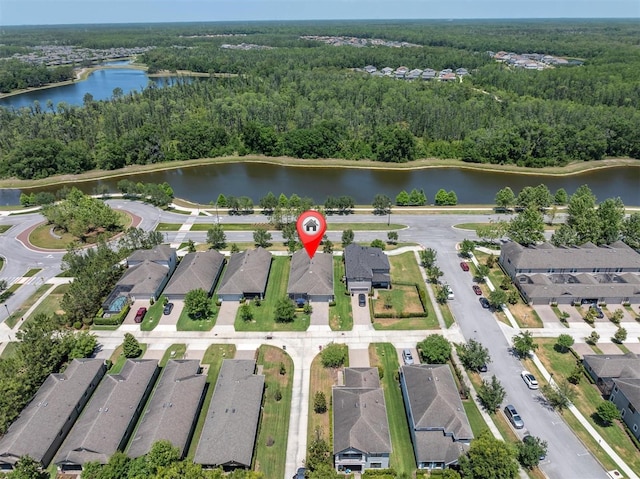 drone / aerial view with a residential view, a view of trees, and a water view