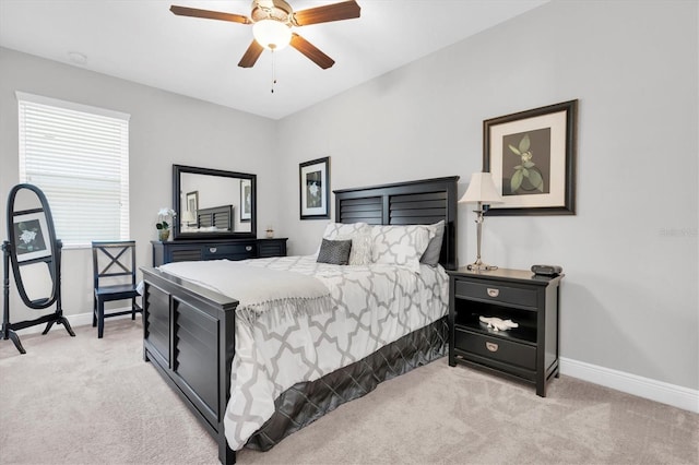 bedroom with light colored carpet, a ceiling fan, and baseboards