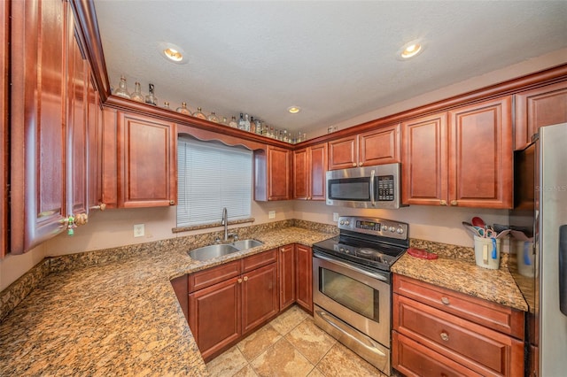 kitchen with recessed lighting, a sink, appliances with stainless steel finishes, and light stone counters