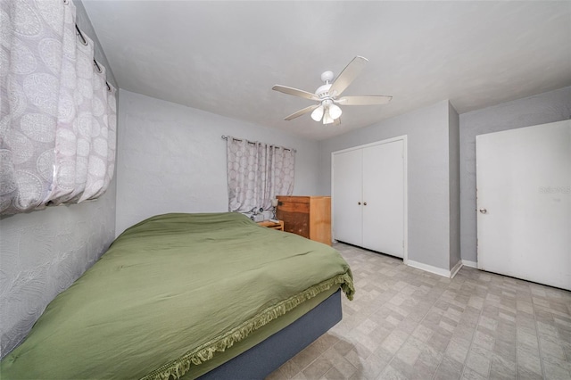 bedroom with a closet, a ceiling fan, and baseboards