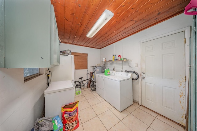 washroom with gas water heater, cabinet space, wooden ceiling, light tile patterned flooring, and washer and clothes dryer