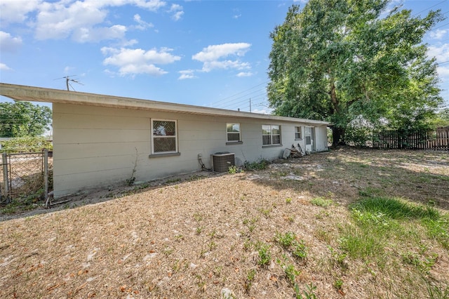 rear view of property with fence and central AC unit