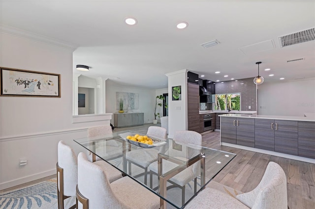 dining area featuring recessed lighting, visible vents, ornamental molding, and light wood-style flooring