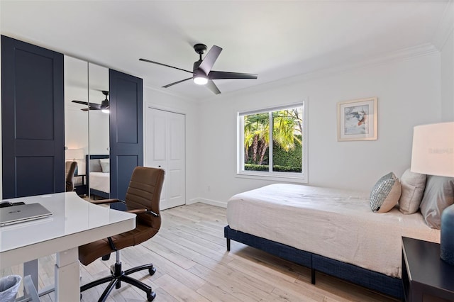 bedroom with ceiling fan, baseboards, a closet, ornamental molding, and light wood-style flooring
