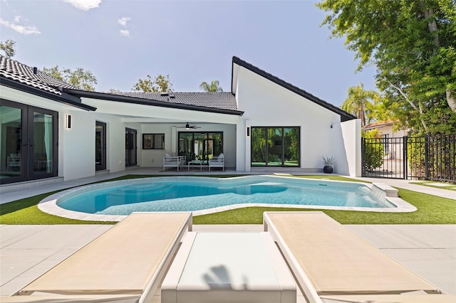view of swimming pool with fence, a patio, french doors, a fenced in pool, and a ceiling fan
