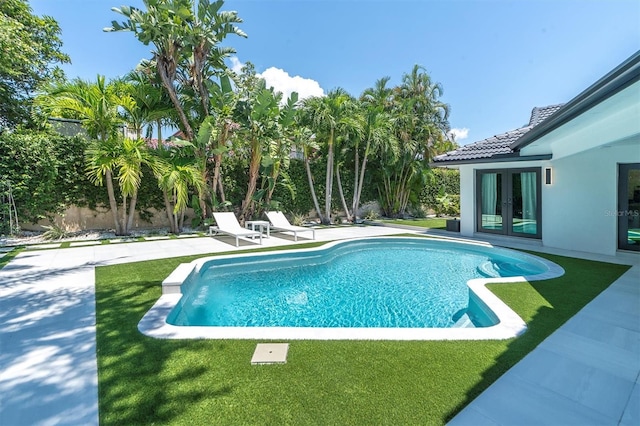 pool with a lawn, french doors, a fenced backyard, and a patio area