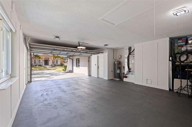 garage with baseboards, heating unit, and water heater