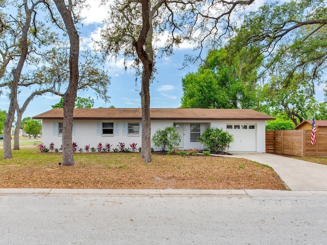 1700 25th St N, Saint Petersburg, FL 33713 - ranch-style home featuring fence, a garage, stucco siding, a front yard, and concrete driveway