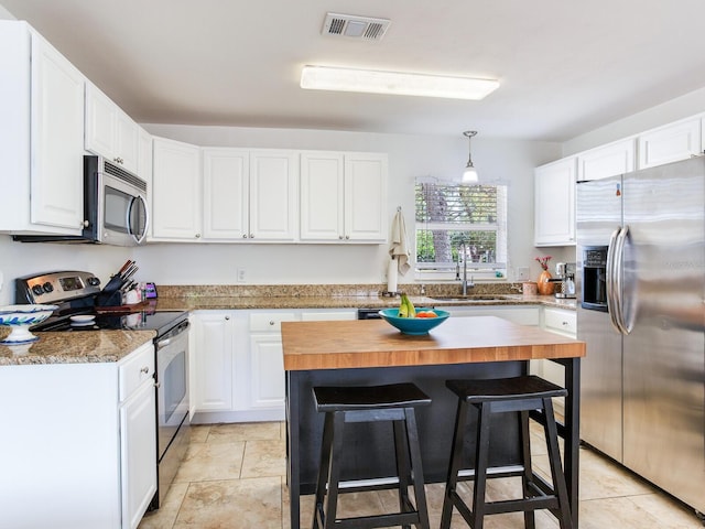1700 25th St N, Saint Petersburg, FL 33713 - kitchen featuring a sink, wood counters, appliances with stainless steel finishes, and white cabinets