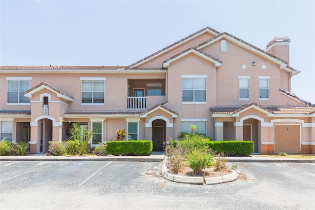 10473 Villa View Cir, Tampa, FL 33647 - townhome / multi-family property featuring stucco siding, a chimney, a balcony, a tiled roof, and uncovered parking
