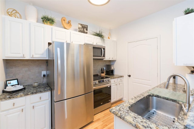 10473 Villa View Cir, Tampa, FL 33647 - kitchen featuring white cabinets, a sink, light wood-style flooring, appliances with stainless steel finishes, and backsplash