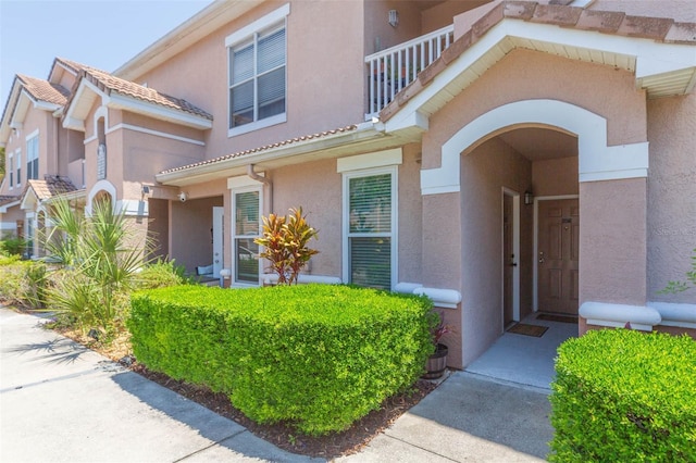 10473 Villa View Cir, Tampa, FL 33647 - doorway to property featuring stucco siding, a balcony, and a tile roof