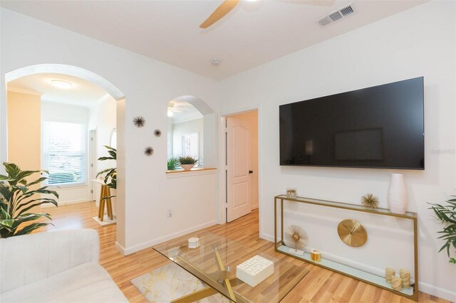 10473 Villa View Cir, Tampa, FL 33647 - living room with visible vents, wood finished floors, baseboards, ceiling fan, and arched walkways