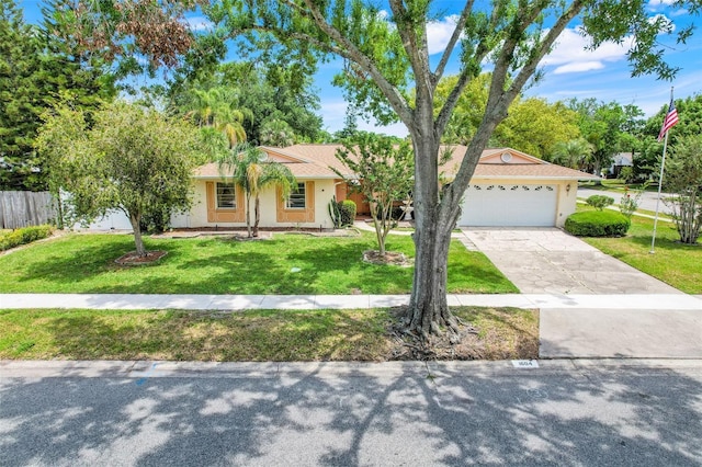 ranch-style house with a garage, a front lawn, stucco siding, and concrete driveway
