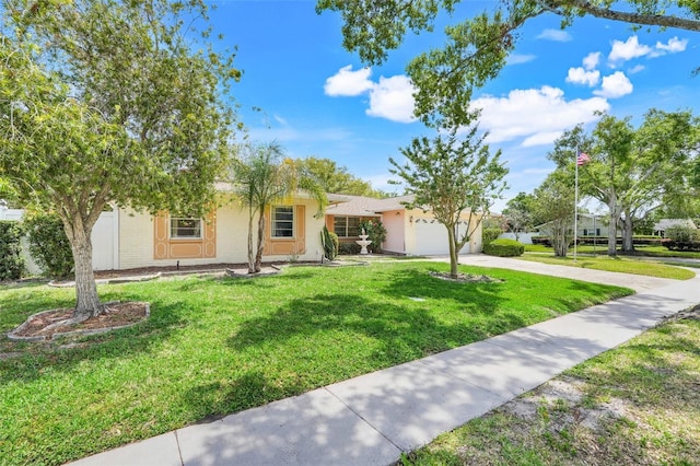 single story home featuring an attached garage, a front lawn, stucco siding, and driveway